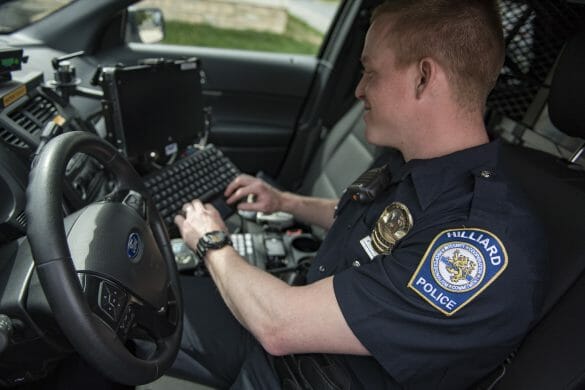 Officer working on computer in car