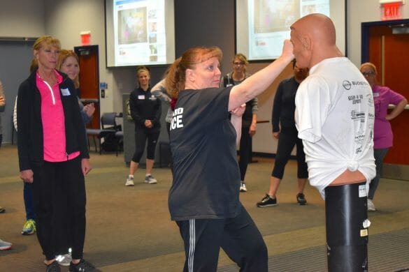 officer demonstrating self-defense to women