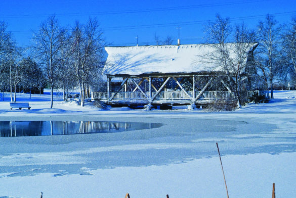 Snow covered lake and bridge at Homestead park in winter.