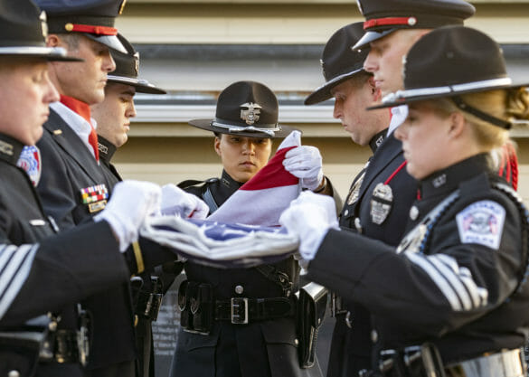 Officers folding the American flag during the police memorial ceremony