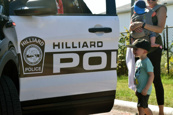 A little boy looking into a police cruiser