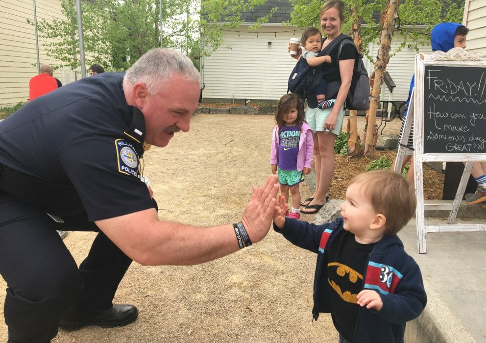 An officer high fiving a little boy