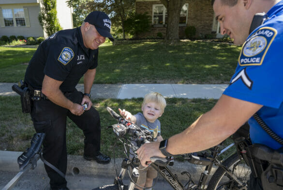 Officers showing police bicycle to a kid