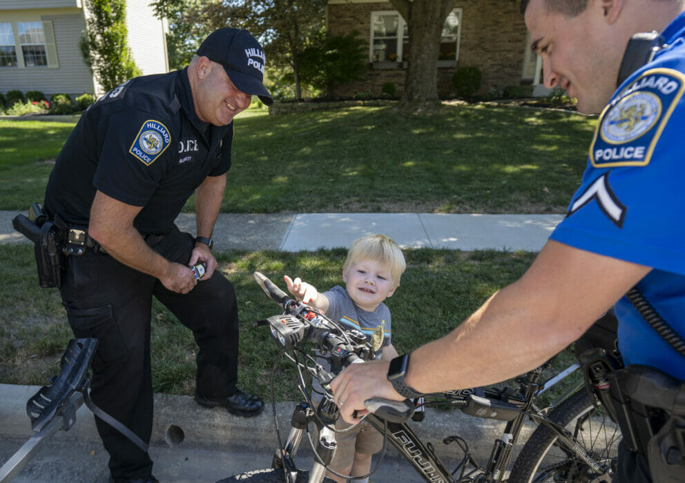 Officers showing police bicycle to a kid
