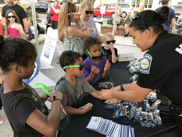 A female officer giving kids police swag