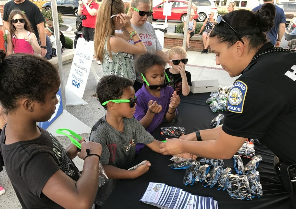 A female officer giving kids police swag