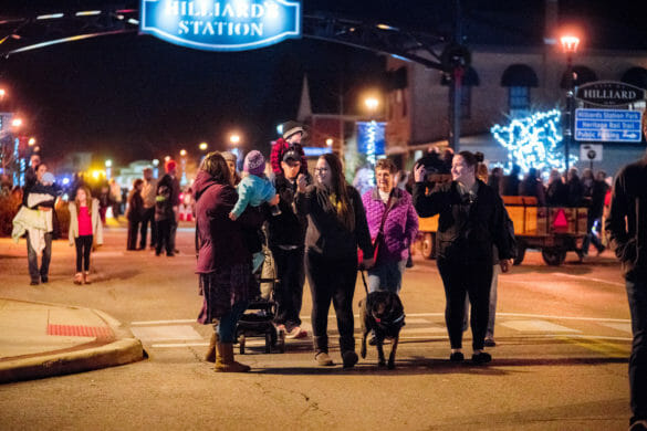 People walking around with dog at Tree Lighting event