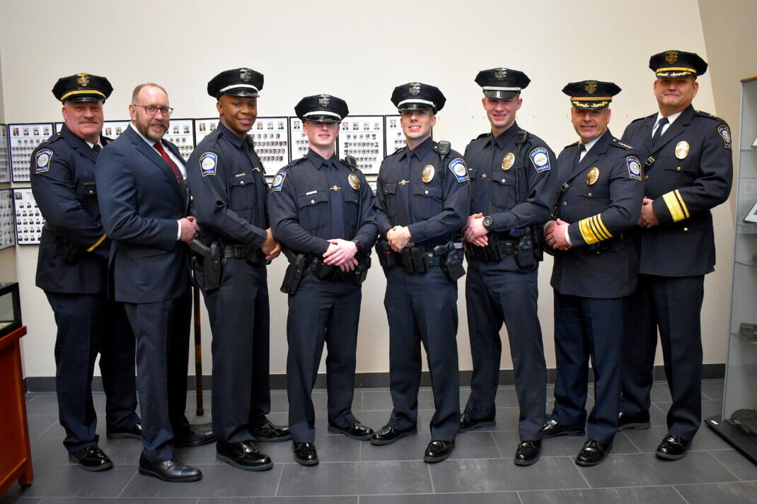 New police officers standing with Chief Fischer, Deputy Chief Grille, and Safety Director Mossic.