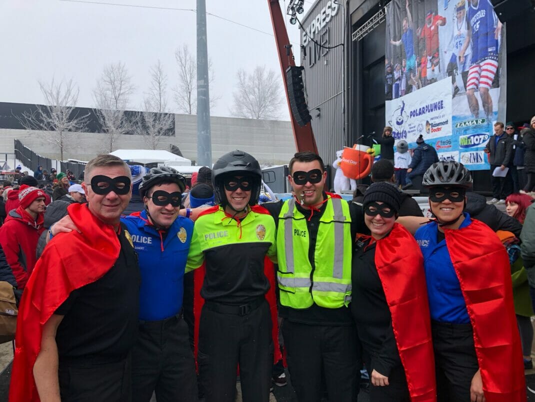 Police officers dressed in masks and red capes for Special Olympics