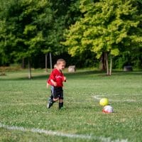 Two little boys kicking a soccer ball