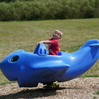 A boy in a plane at a park