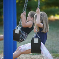 Two girls swinging
