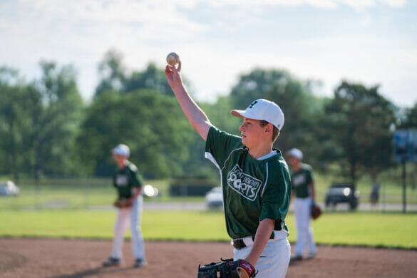 A boy holding a baseball up