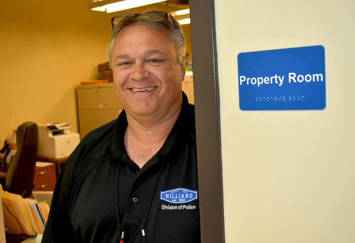 Todd Harper standing in doorway smiling, next to Property Room sign