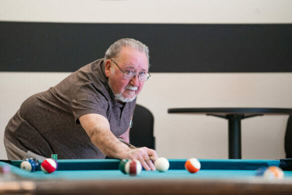 An older man playing pool