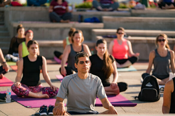 A man surrounded by women doing yoga