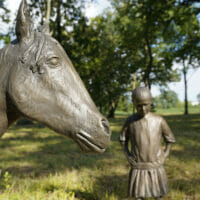 The head of a horse sculpture and a little girl scultpure