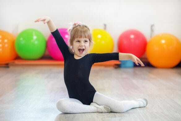 Little preschooler girl learning dance and smiling. The concept of sports, education, hobbies, training and dance.