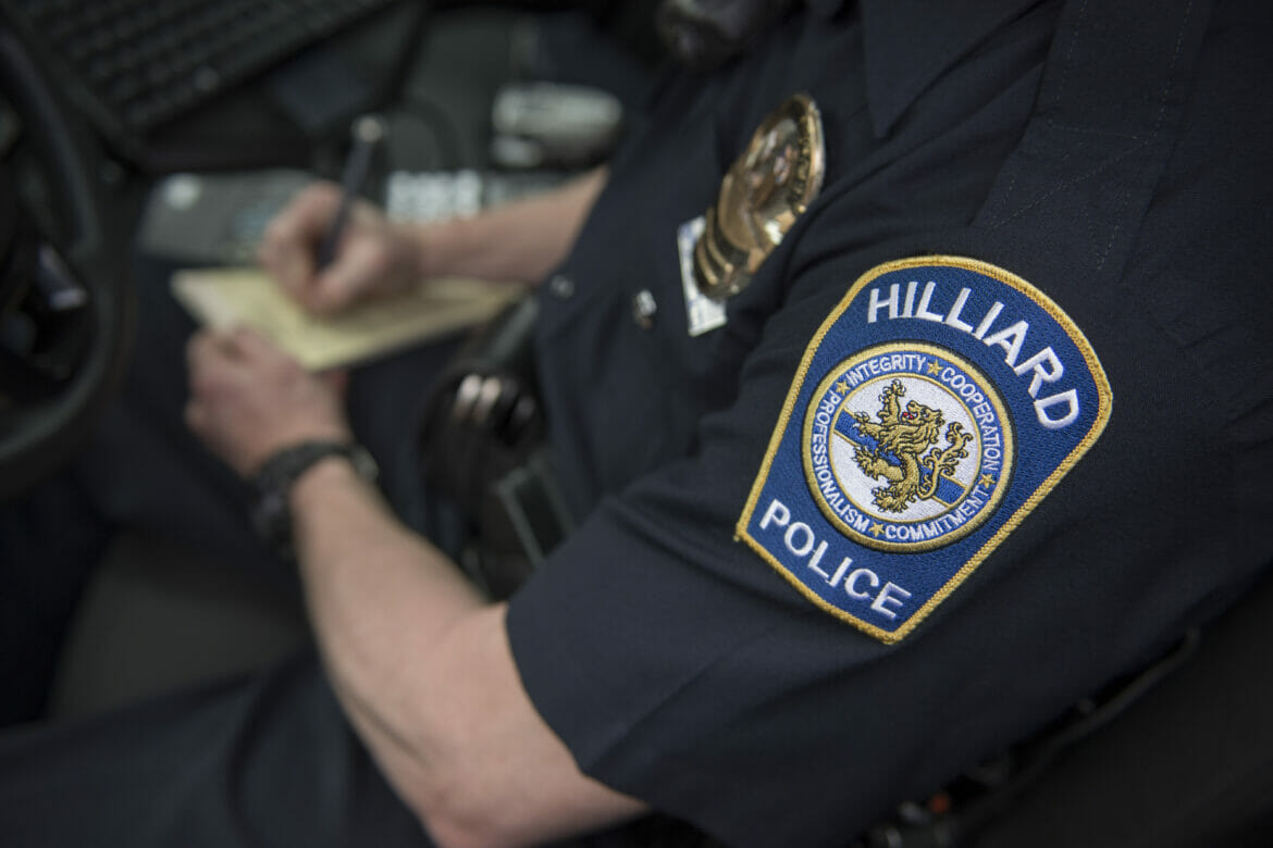 Close up of police badge as officer writes ticket