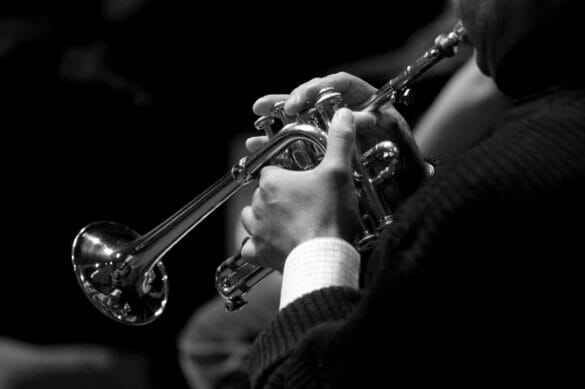 black and white photo of man playing trumpet