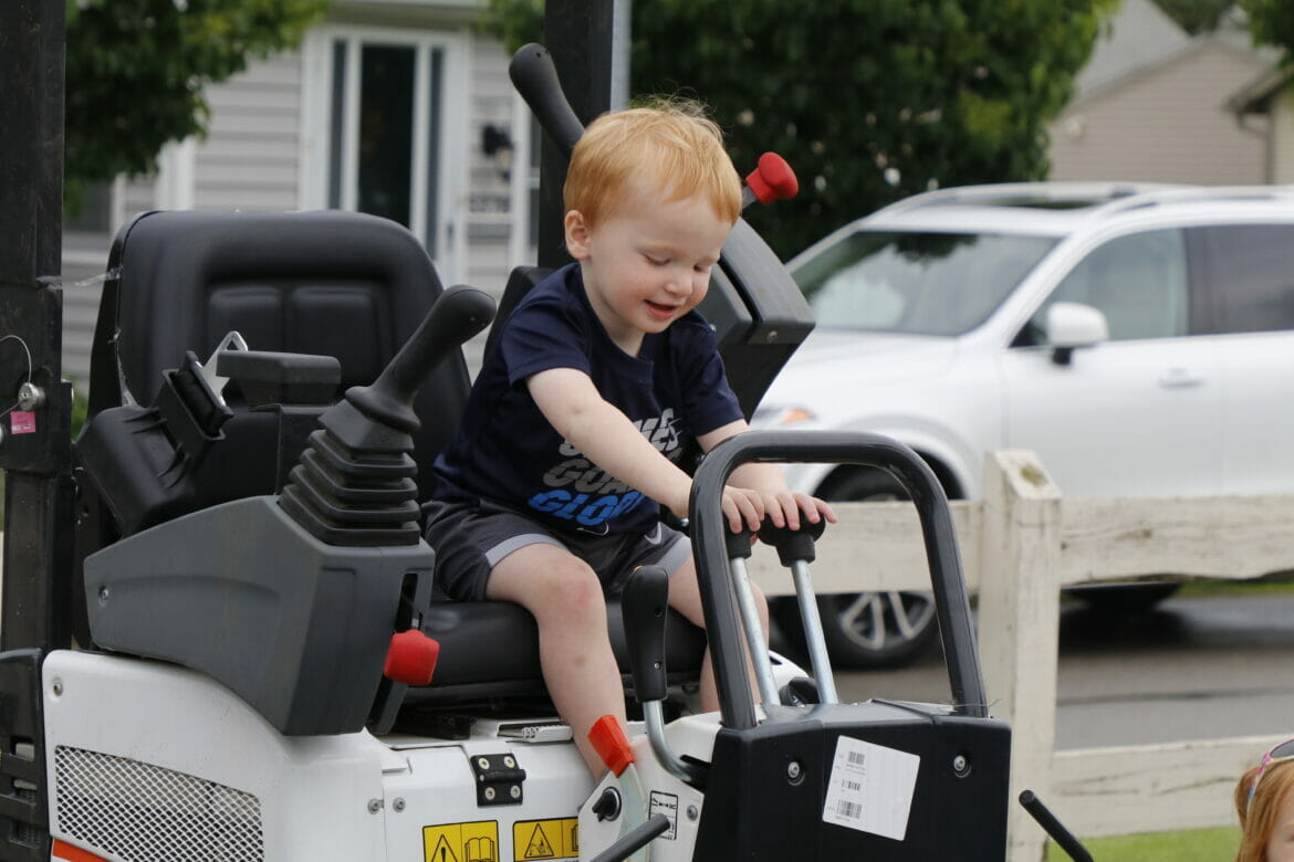 little boy on top of mower