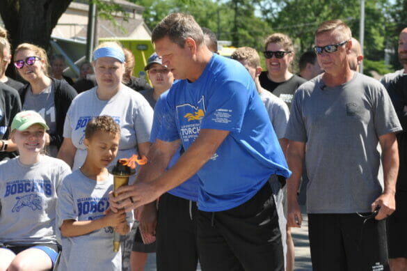Former Chief of Police Eric Grile handing off the torch for the special Olympics