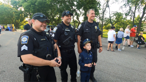Officers posing with little boy dressed as an officer
