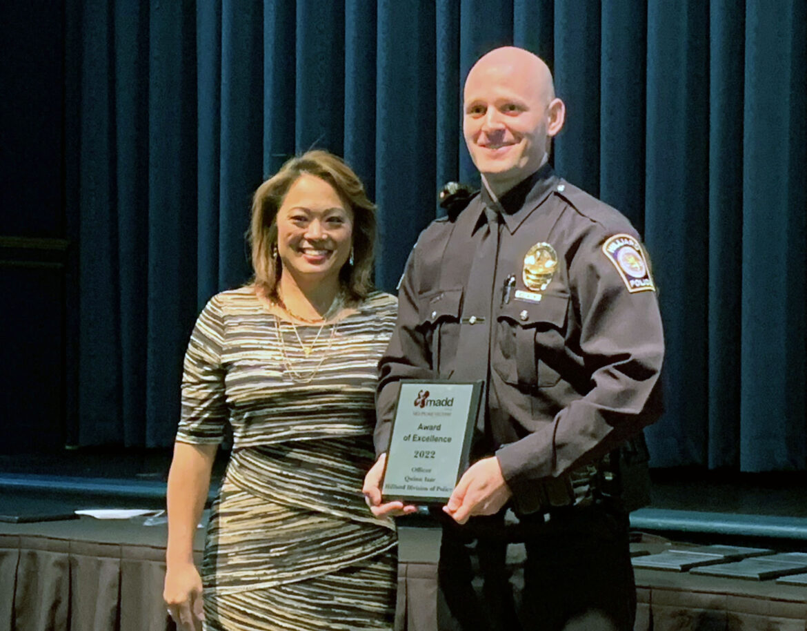 Officer Izar accepts the 2022 MADD Award of Excellence from Angela An. 
