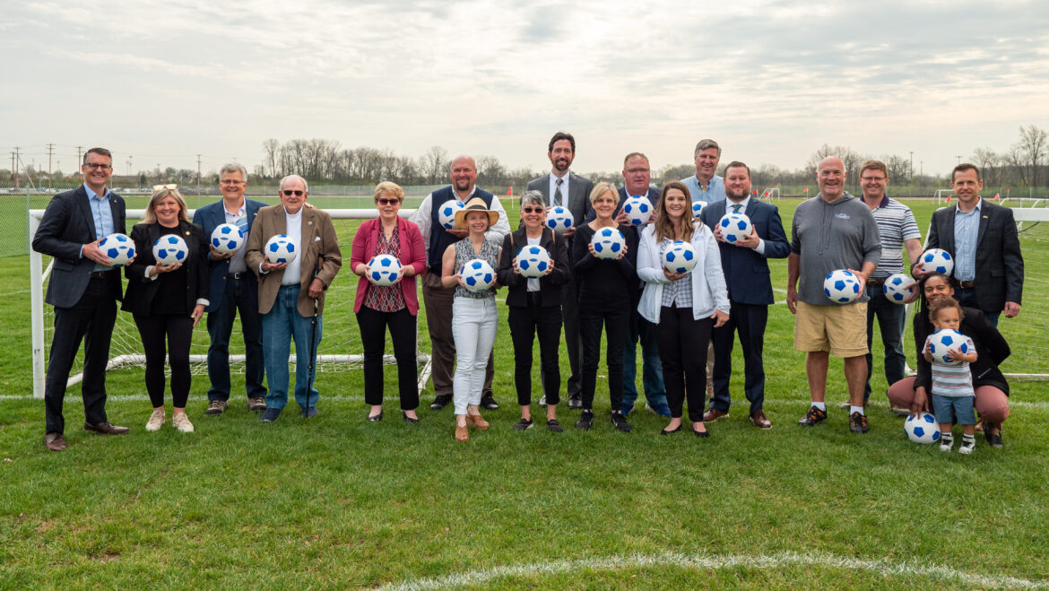 Lineup of people holding soccer balls