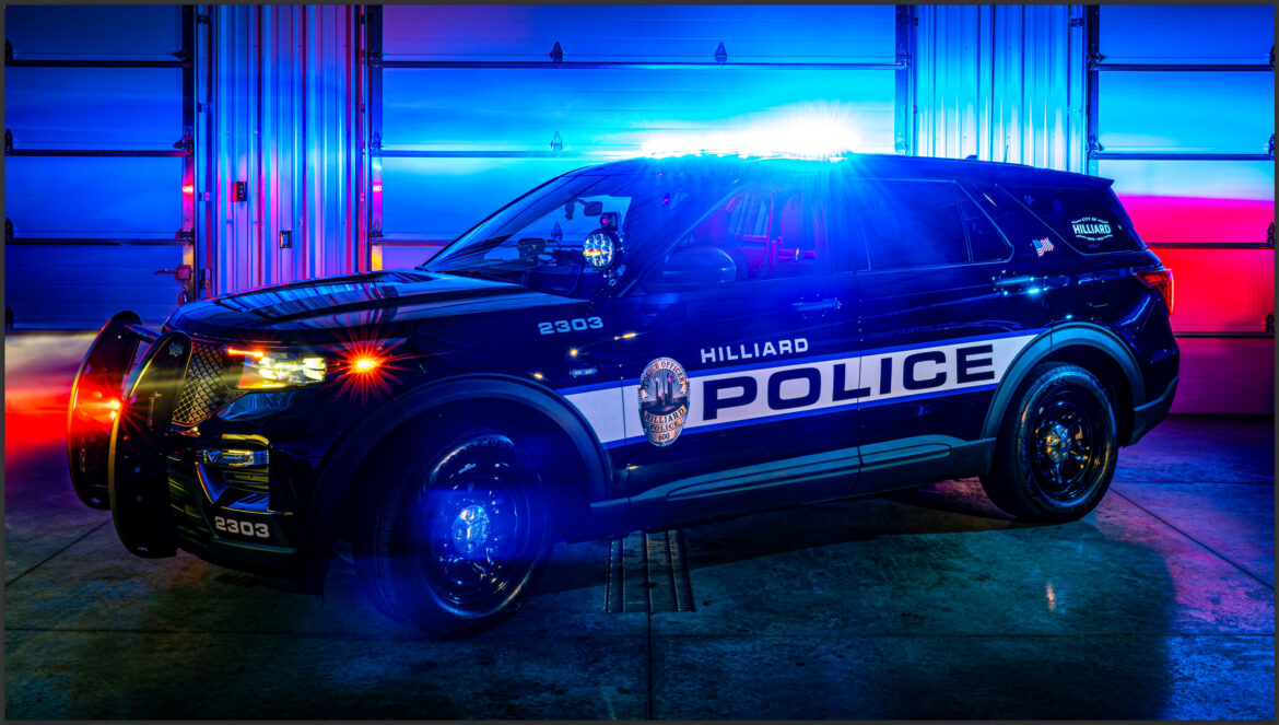 Hilliard police car with red and blue lights reflecting through fog. 