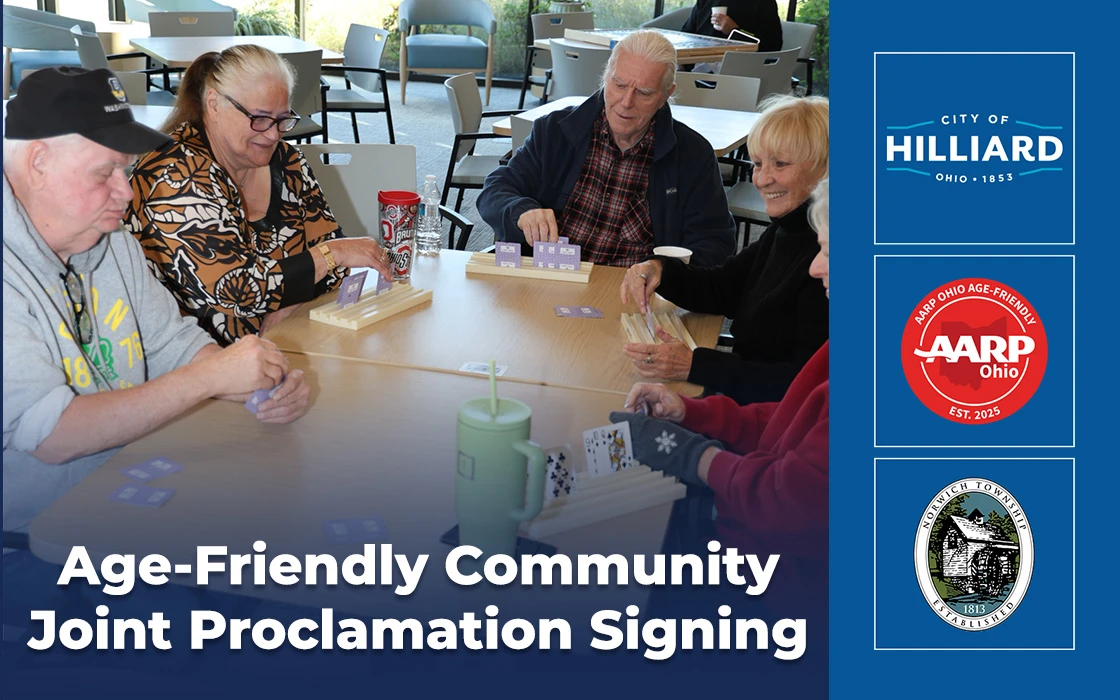 Several seniors sit around a table playing cards