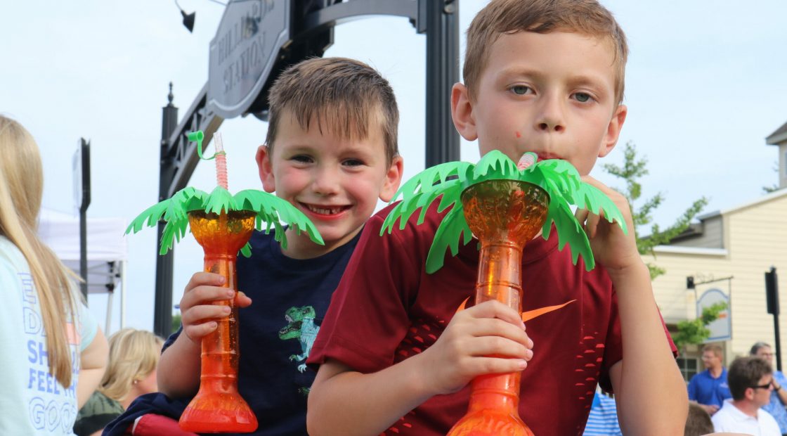 Boys drinking from palm tree cups