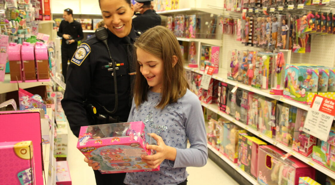 Officer with little girl looking at toys