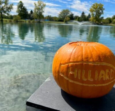 Pumpkin that says Hilliard sitting beside lake